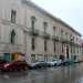 ...il cui palazzo (oggi sede di un istituto di credito) si staglia accanto al tempietto